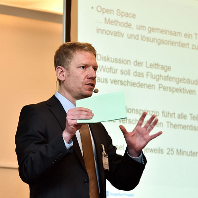 Moderator Timon Meyer bei der Moderation einer Veranstaltung im Rahmen des Leitbildprozesses für den ehemaligen Flughafen Tempelhof